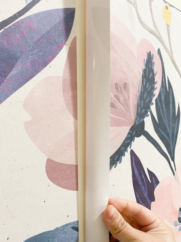 Close detail of a colorful mural wallpaper being installed