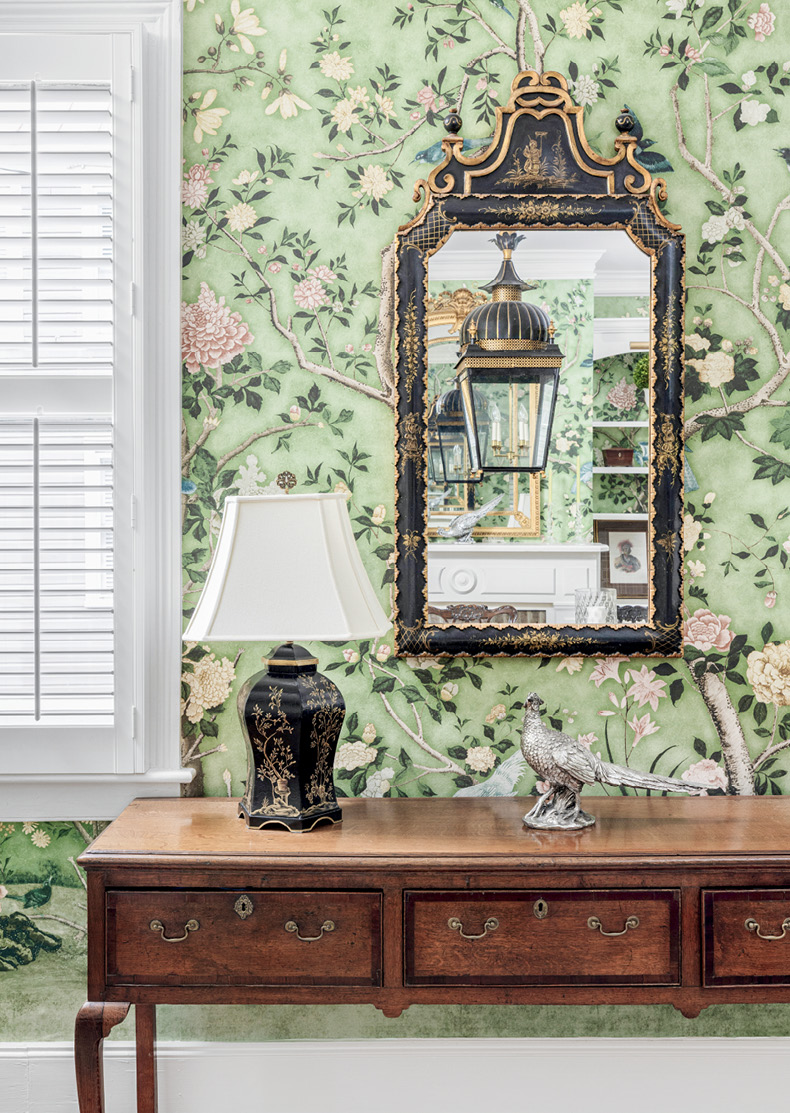 Wallpapered dining interior with framed mirror